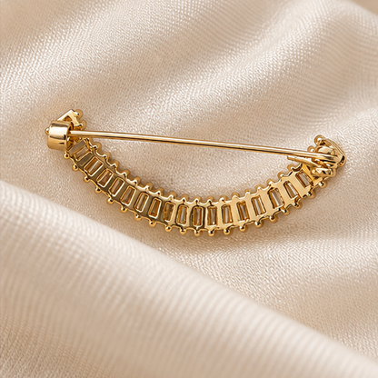 Broche dorée arc élégant avec cristaux baguette transparents, accessoire mode femme pour veste ou écharpe