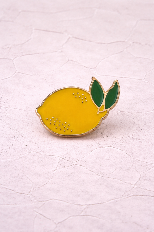 Pin's émaillé citron jaune vif finitions dorées feuilles vertes