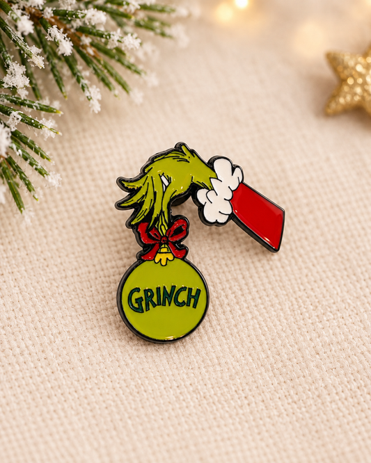 Pin's Grinch Noël vert main tenant boule ornement rouge, accessoire fantaisie fêtes Dr Seuss
