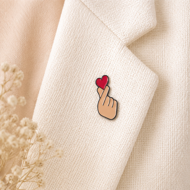 Pin's finger heart rouge émaillé avec geste coréen cœur des doigts sur revers blazer écru accessoire kawaii tendance
