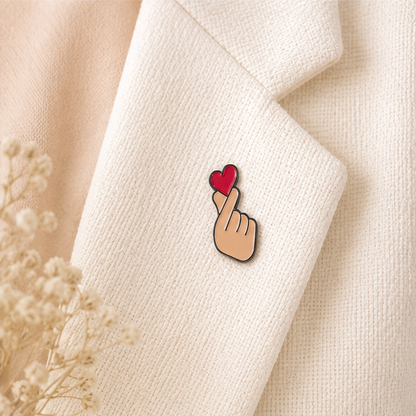 Pin's finger heart rouge émaillé avec geste coréen cœur des doigts sur revers blazer écru accessoire kawaii tendance
