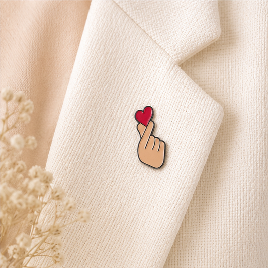 Pin's finger heart rouge émaillé avec geste coréen cœur des doigts sur revers blazer écru accessoire kawaii tendance