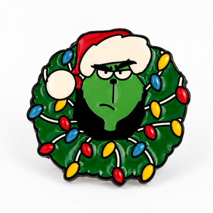 Pin's Grinch Noël en émail vert avec couronne lumineuse colorée et bonnet rouge, accessoire fantaisie fêtes de fin d'année