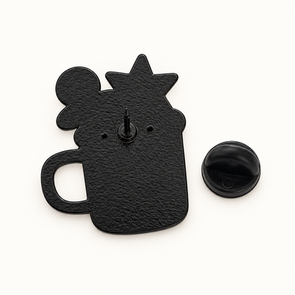 Pin's métal noir forme tasse de Noël avec étoile et boule, dos texturé avec attache papillon, accessoire festif original