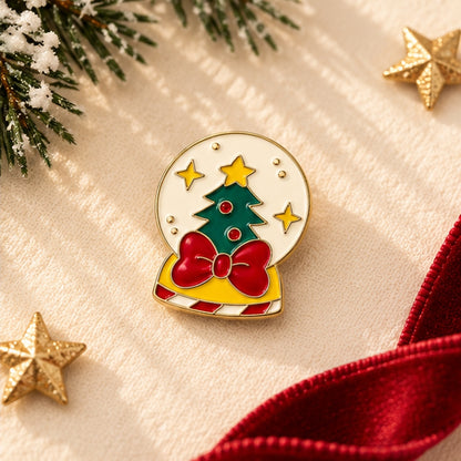 Pin's boule à neige de Noël avec sapin vert, étoiles dorées et nœud rouge, accessoire festif émaillé doré