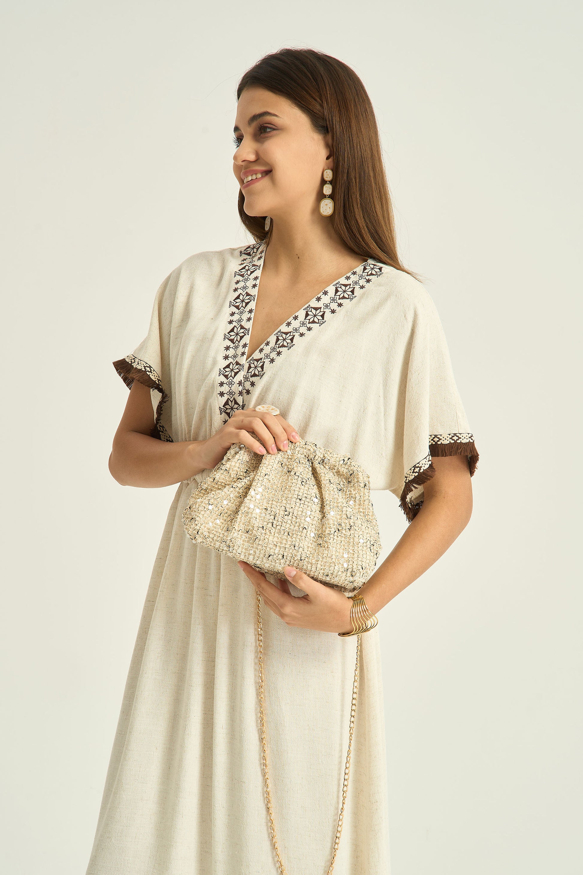 Pochette dorée élégante portée avec robe de cérémonie