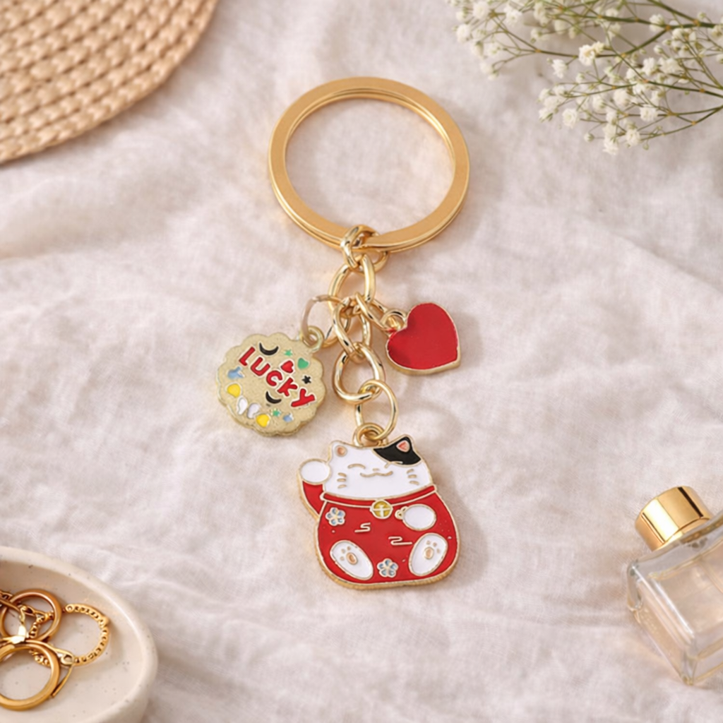 Porte-clés rouge et doré Maneki Neko avec breloques cœur et Lucky sur fond lifestyle