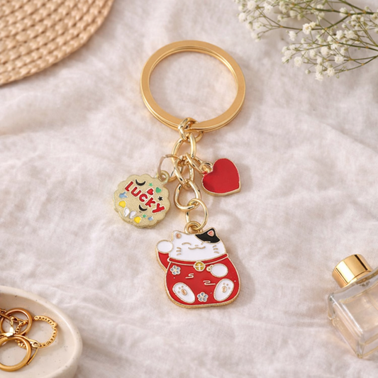 Porte-clés rouge et doré Maneki Neko avec breloques cœur et Lucky sur fond lifestyle