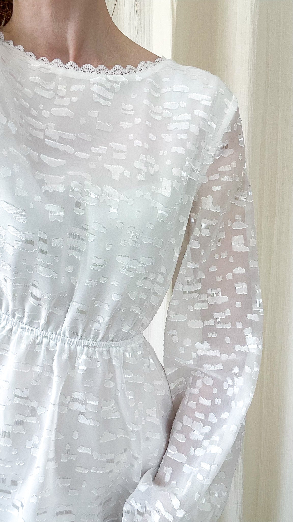 Détail tissu texturé robe blanche Celosia manches longues transparentes