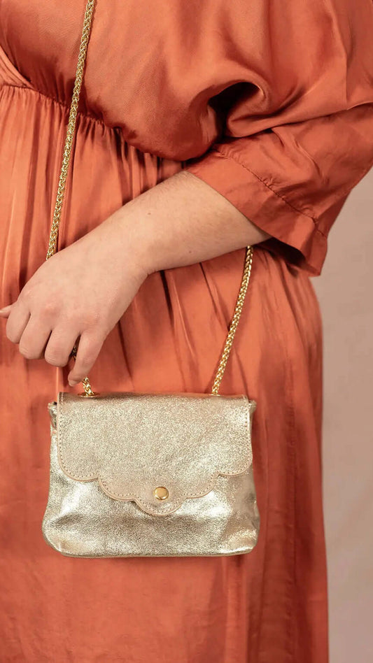 Sac en cuir doré porté avec robe de cérémonie
