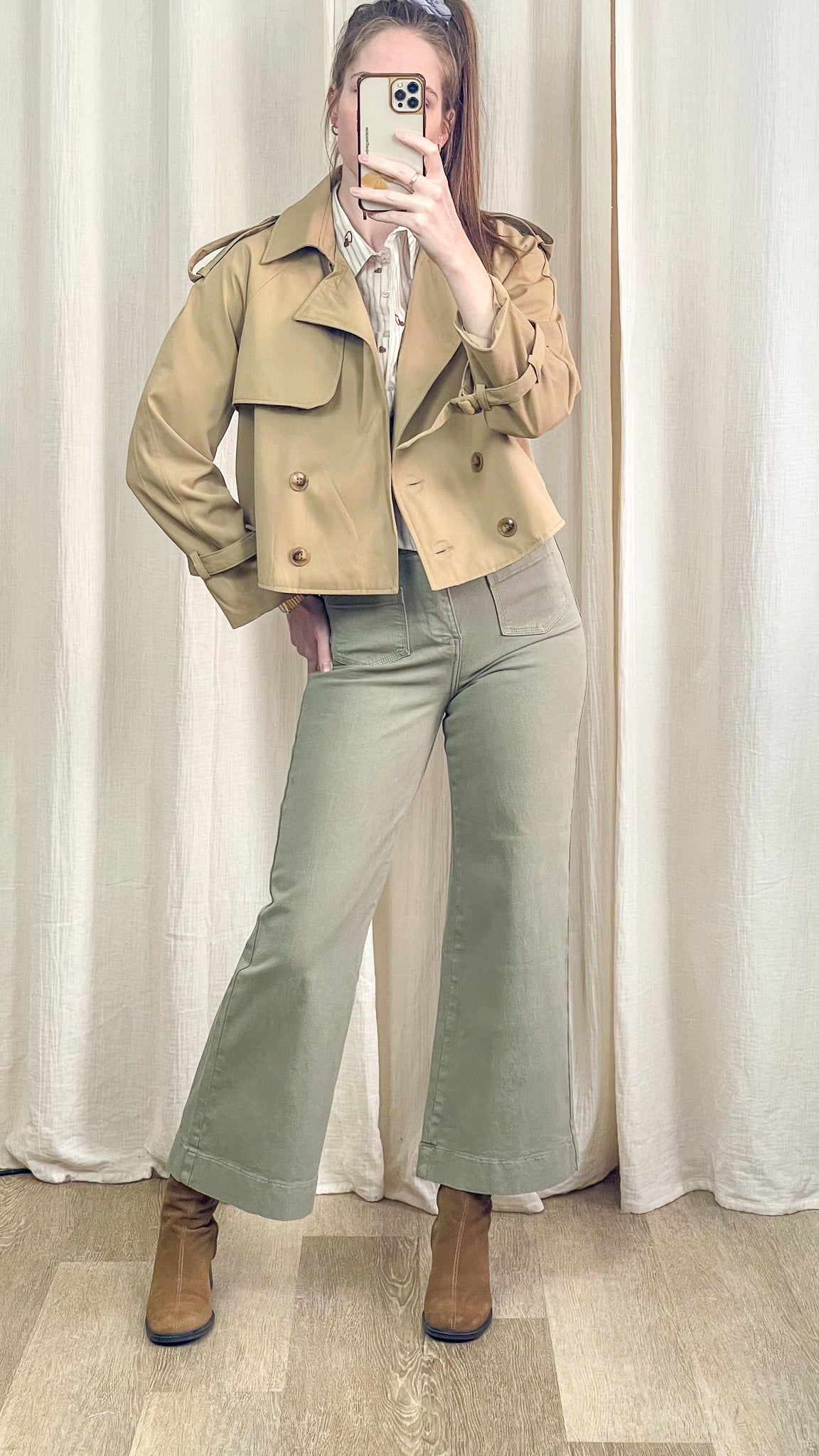 Trench court beige femme porté avec pantalon vert et bottines look complet